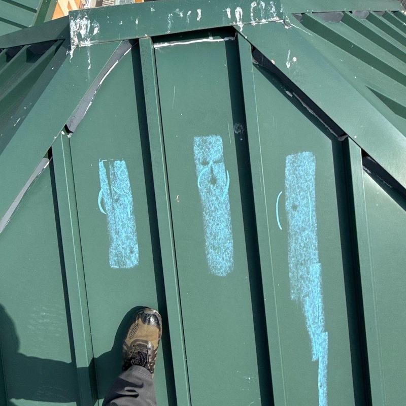 Metal roofing panels with chalk-marked hail damage