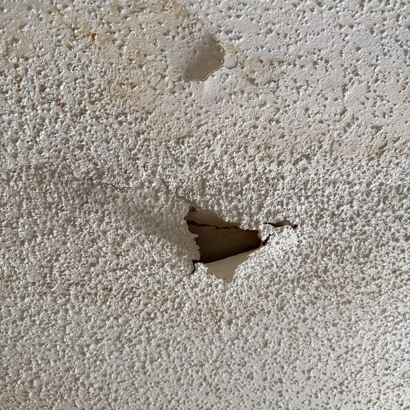 Popcorn ceiling with puncture hole and water damage