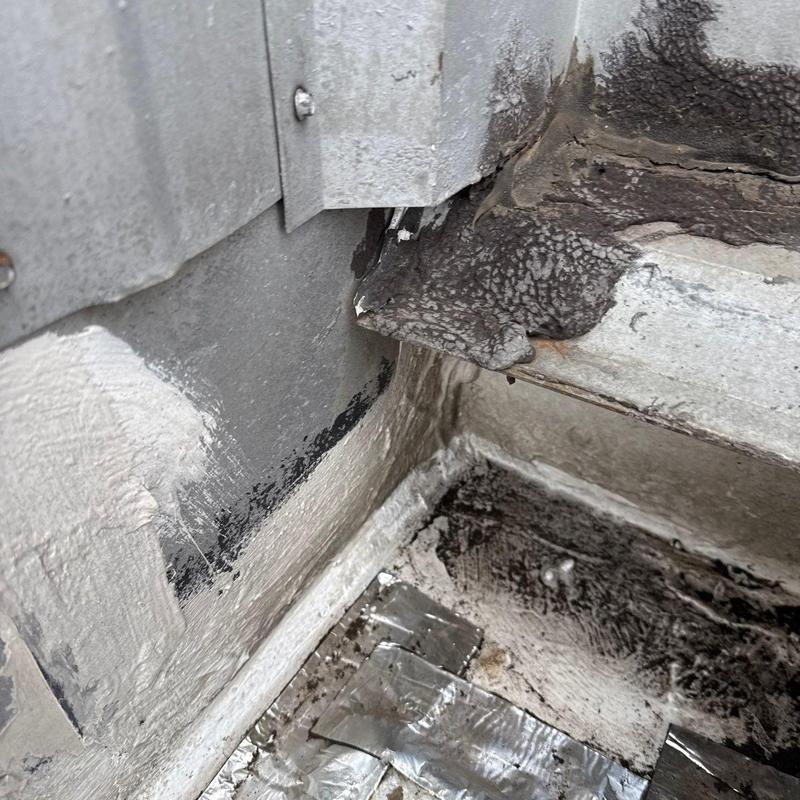 Roof flashing with cracked sealant and hail damage
