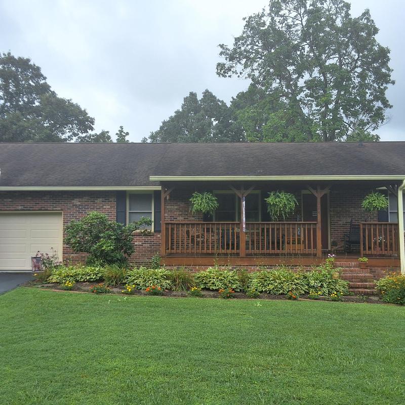 Asphalt shingle roof on brick home with porch