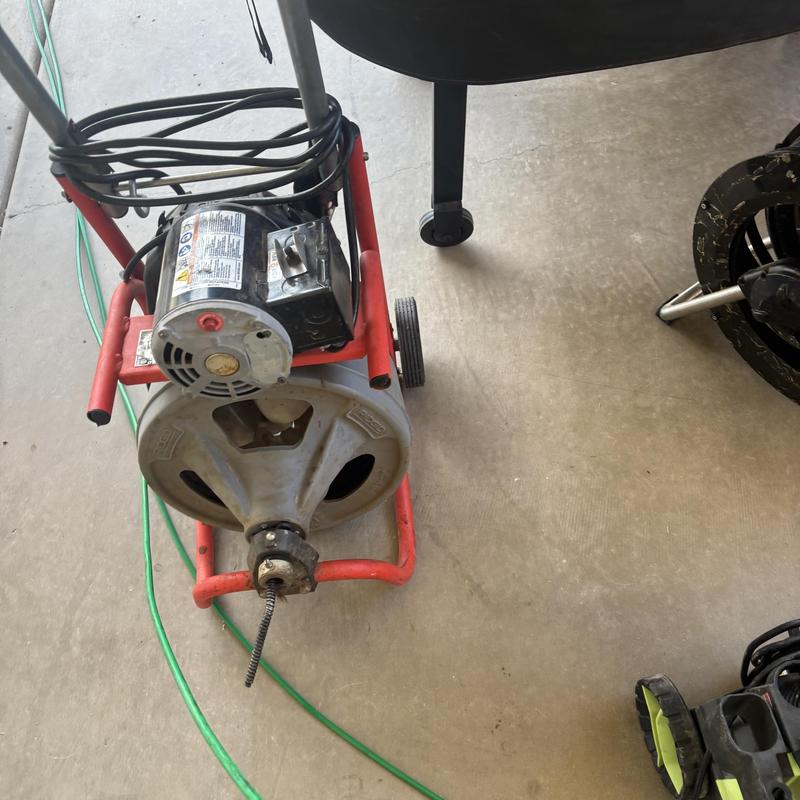 Hydro jet machine with drain cleaning cable spool