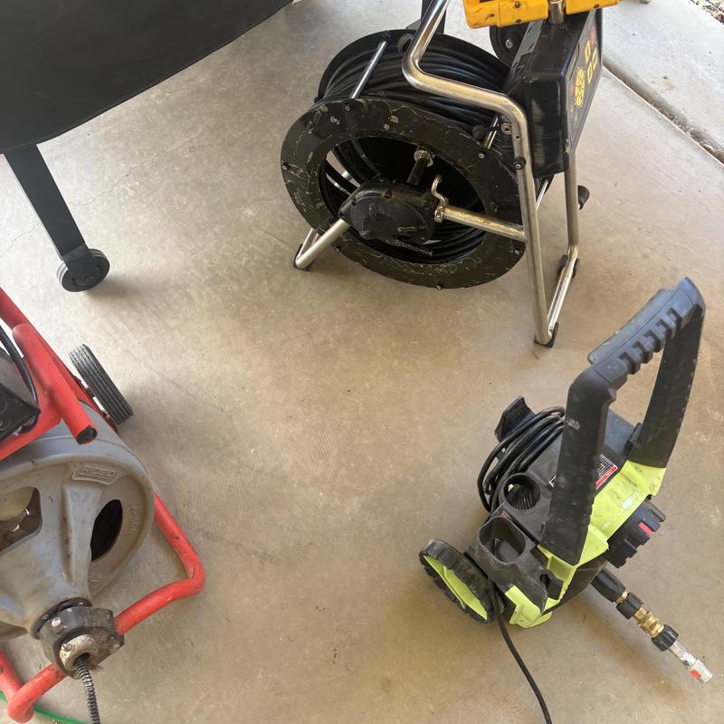 Hydro jet machine and drain snake on concrete floor