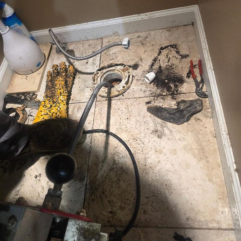 Toilet drain line with plumbing cable and tools Toilet drain line with plumbing cable and tools