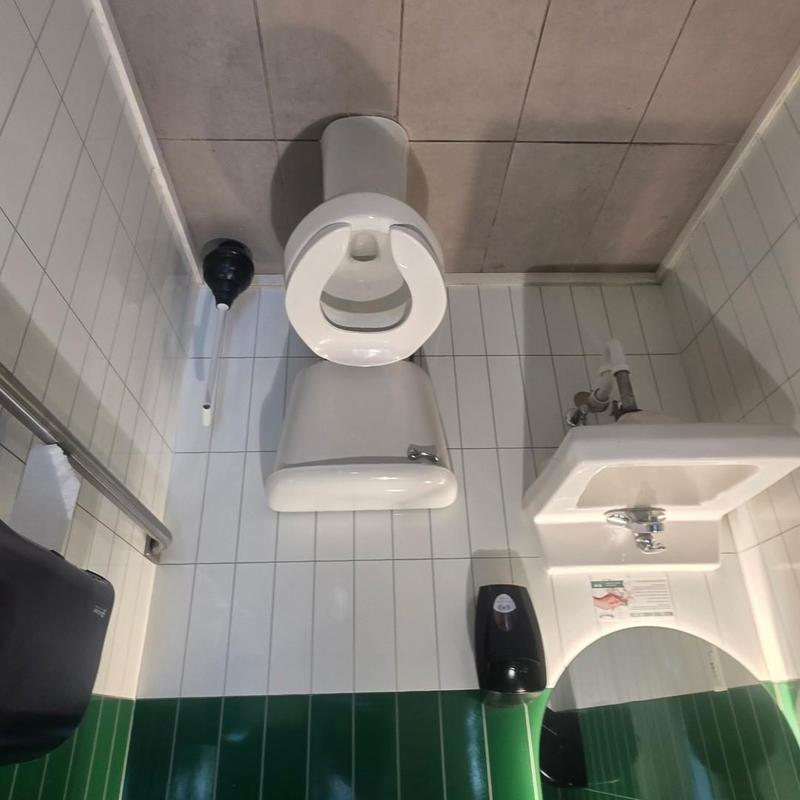 Commercial toilet with nearby sink and plunger Commercial toilet with nearby sink and plunger