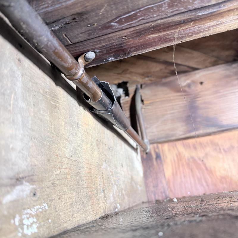 Copper water pipe with soldered fittings under floor joist