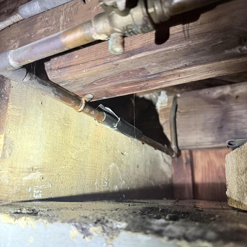 Copper water piping with soldered fittings in crawl space