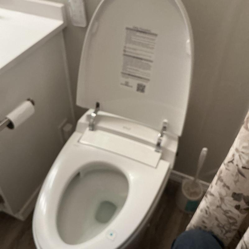 Toilet bowl with open lid in residential bathroom