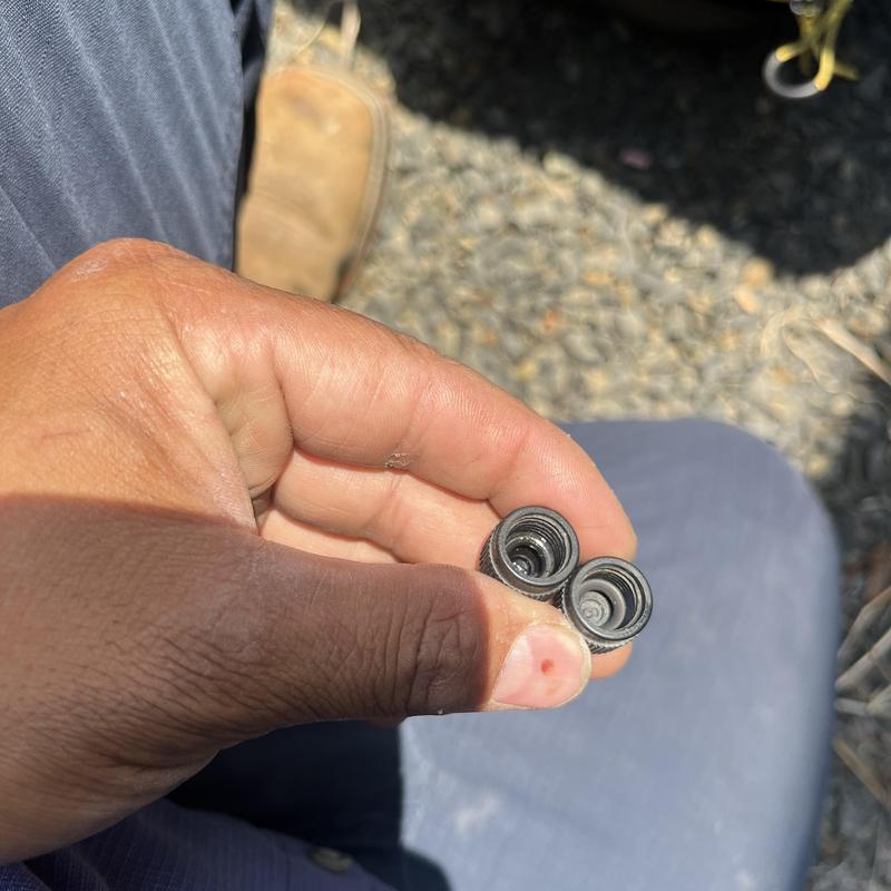 HVAC Schrader core valves held in hand outdoors