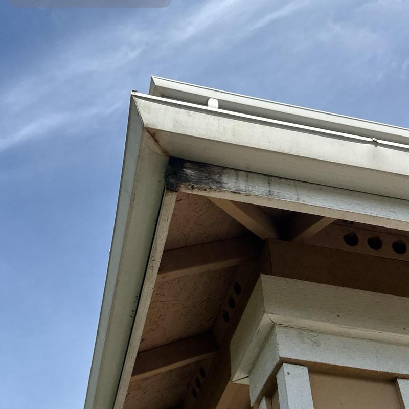 Roof fascia board with water damage and discoloration