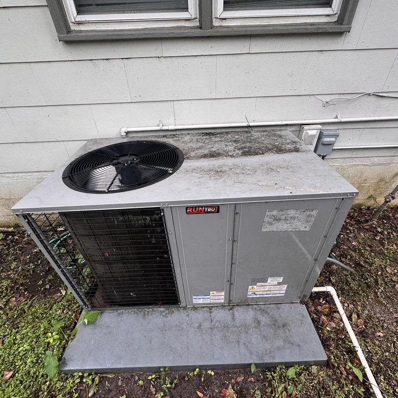 Heat pump package unit exterior near house wall