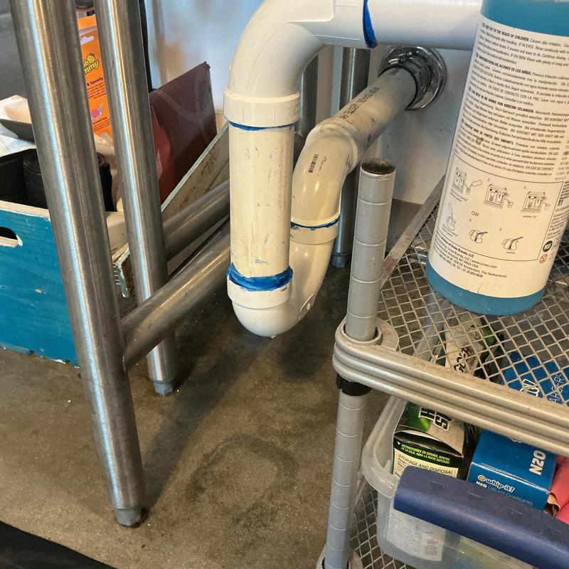 PVC drain pipe under sink during sewer smell investigation