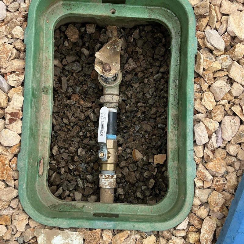 Irrigation shut-off valve in green valve box with gravel Irrigation shut-off valve in green valve box with gravel