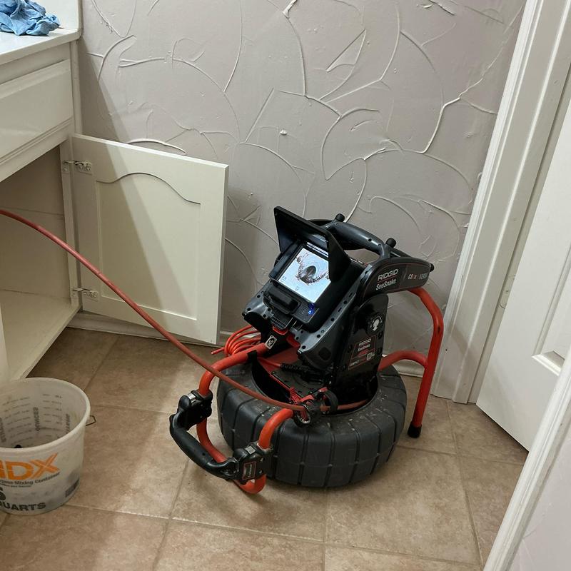 Drain line inspection camera with cable in laundry room