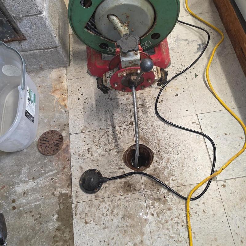 Floor drain auger clearing with plumbing cable machine Floor drain auger clearing with plumbing cable machine