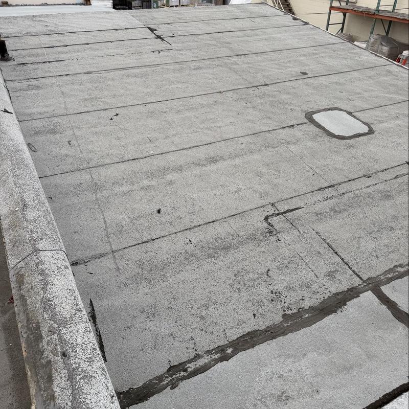 Flat roof torch down membrane with patch repairs Flat roof torch down membrane with patch repairs
