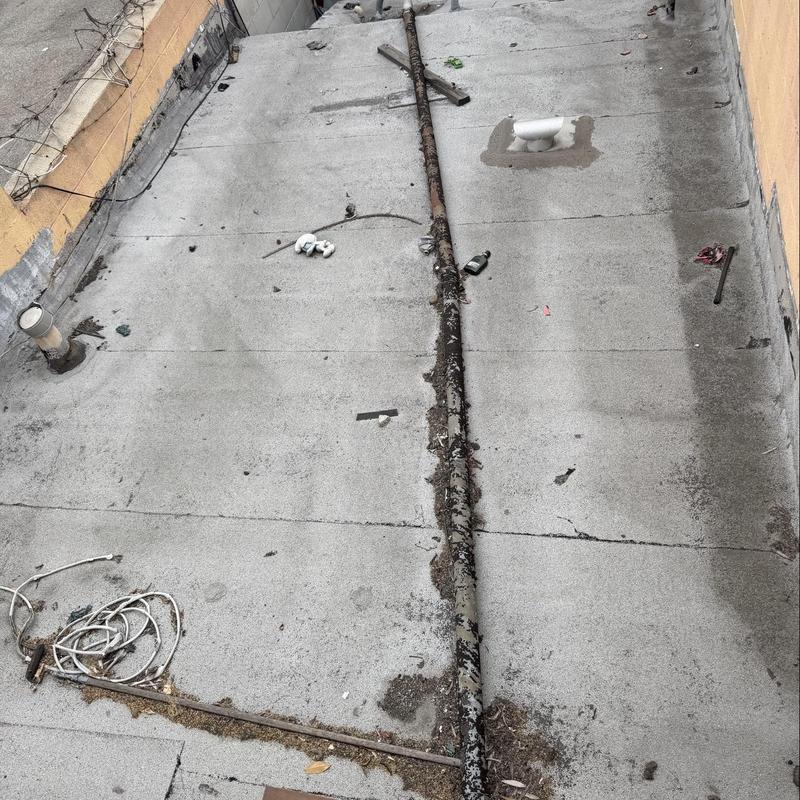 Flat roof torch down membrane with debris and wear Flat roof torch down membrane with debris and wear