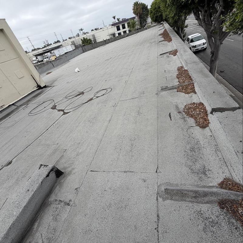Flat torch down roof with debris on edge Flat torch down roof with debris on edge