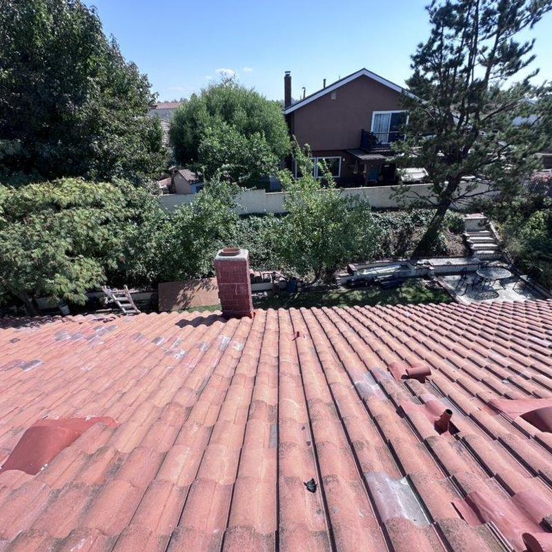 Tile roof with chimney and vents in residential area Tile roof with chimney and vents in residential area