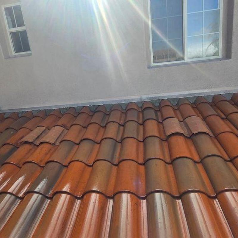 Tile roof installation with sun glare on tiles Tile roof installation with sun glare on tiles