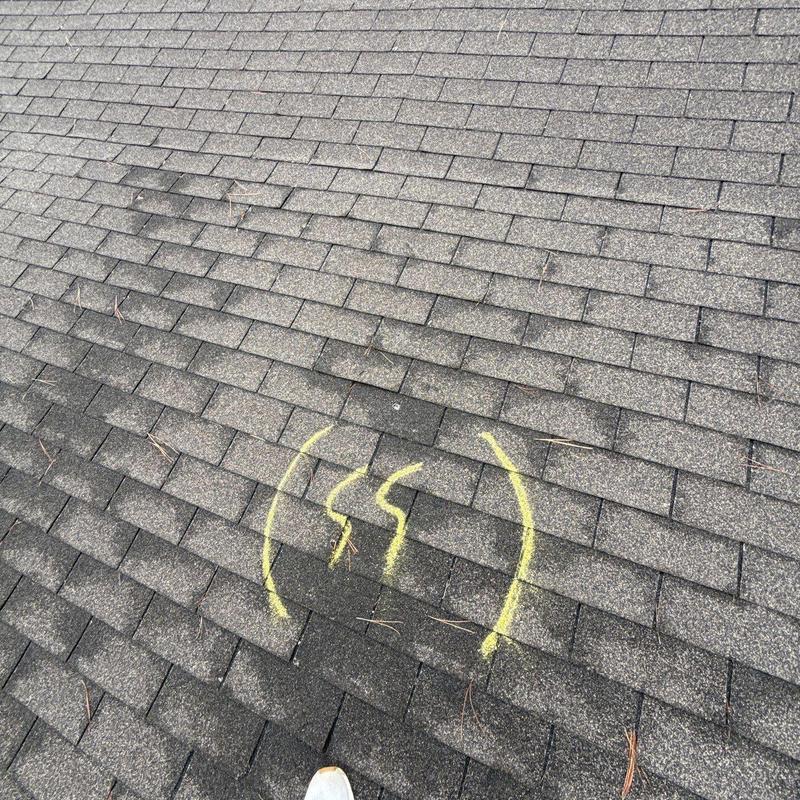 Asphalt shingle roof with hail damage marked in yellow
