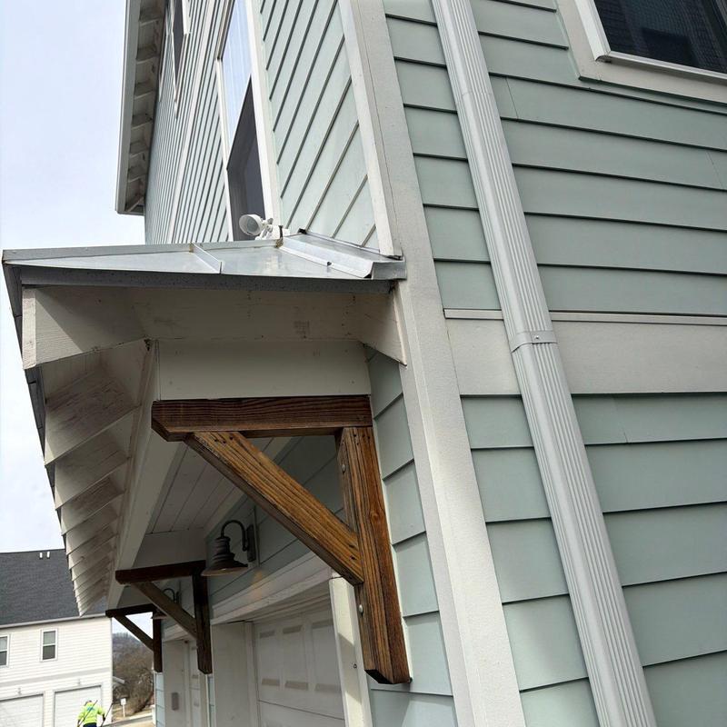 Roof flashing and gutter downspout on house exterior
