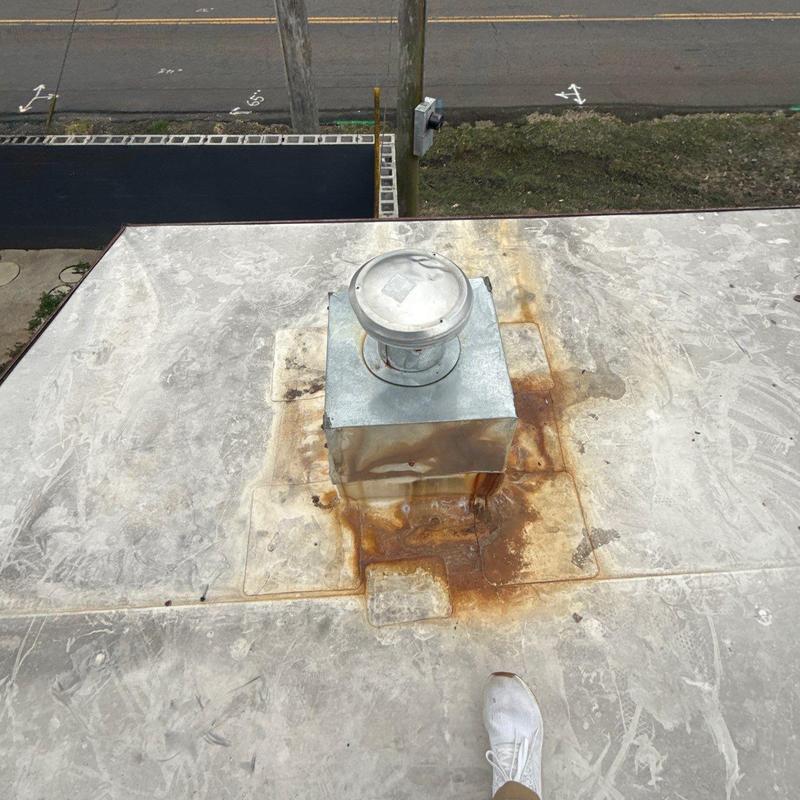 Roof vent with rust and wear on flat motel roof