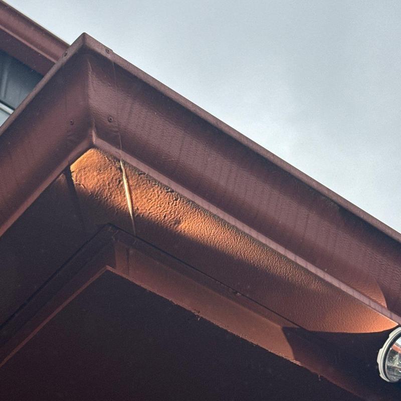 Metal roof flashing with hail damage and rust stains