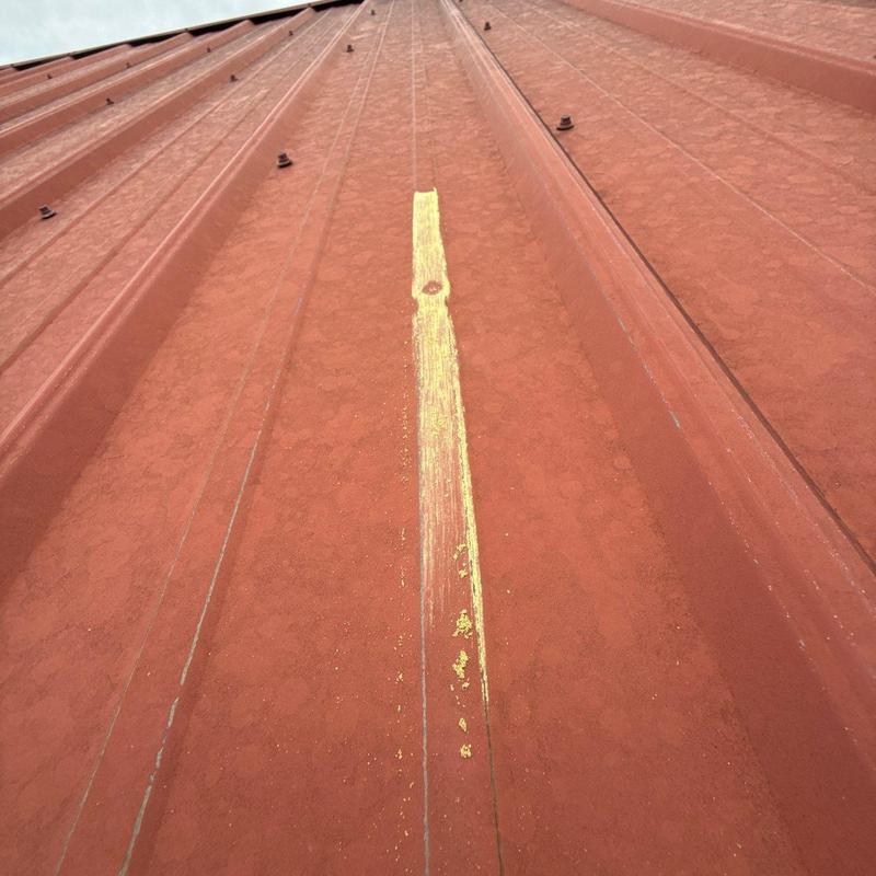 Metal roofing panel with hail damage marked in yellow