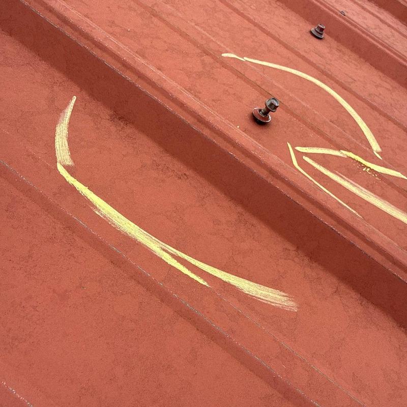 Metal roofing panel with hail damage markings
