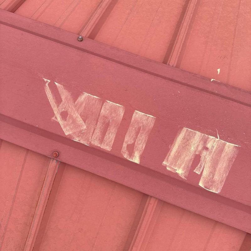 Metal roofing panel with hail damage scratches