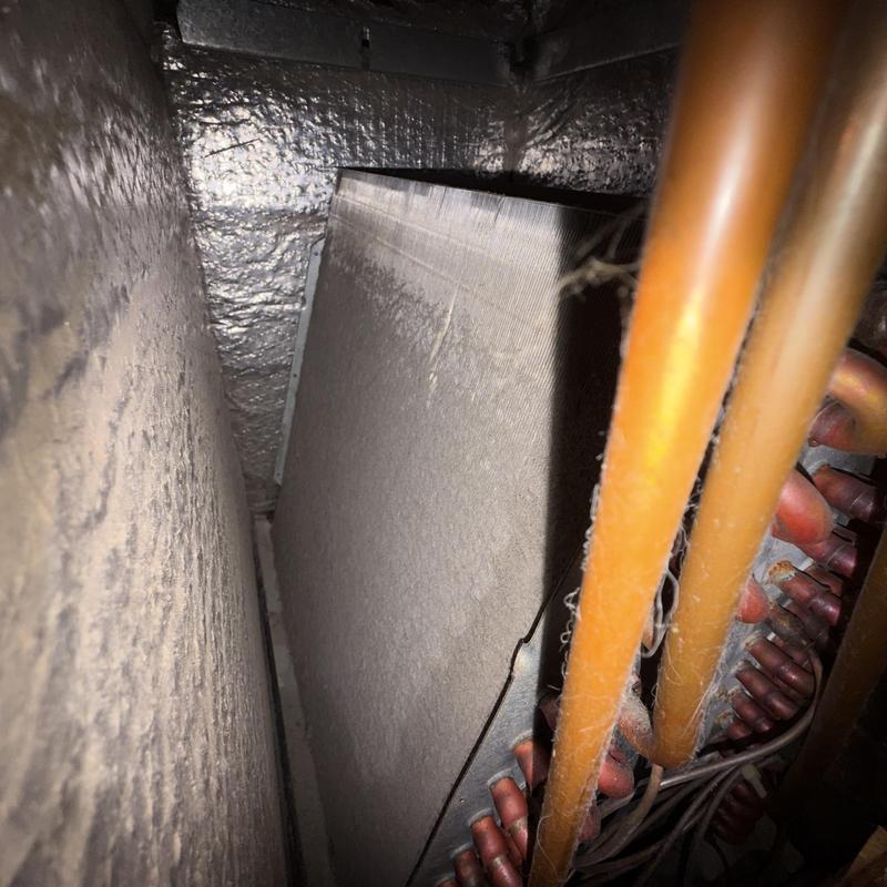 Evaporator coil and copper refrigerant lines inside HVAC unit