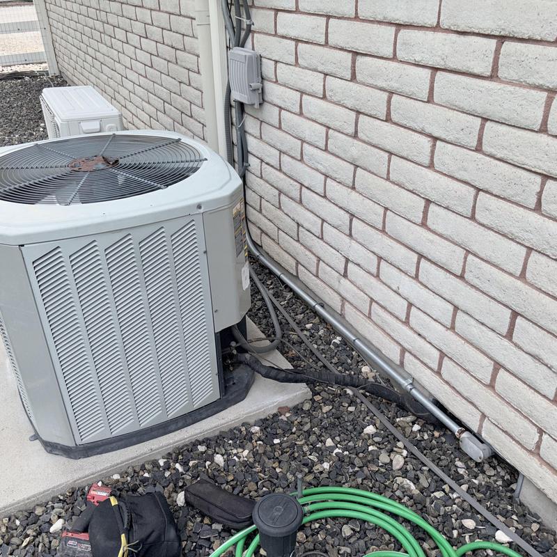 Air conditioning condenser unit with cleaned coils outdoors