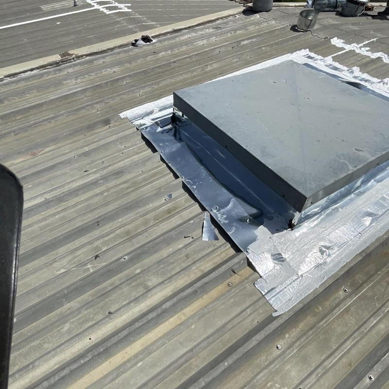 Metal roof skylight flashing with sealant repairs Metal roof skylight flashing with sealant repairs