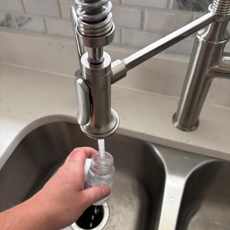 Kitchen faucet filling water sample bottle near sink Kitchen faucet filling water sample bottle near sink