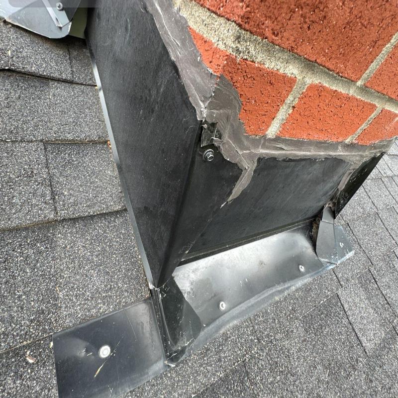 Chimney flashing and roof shingles detail inspection