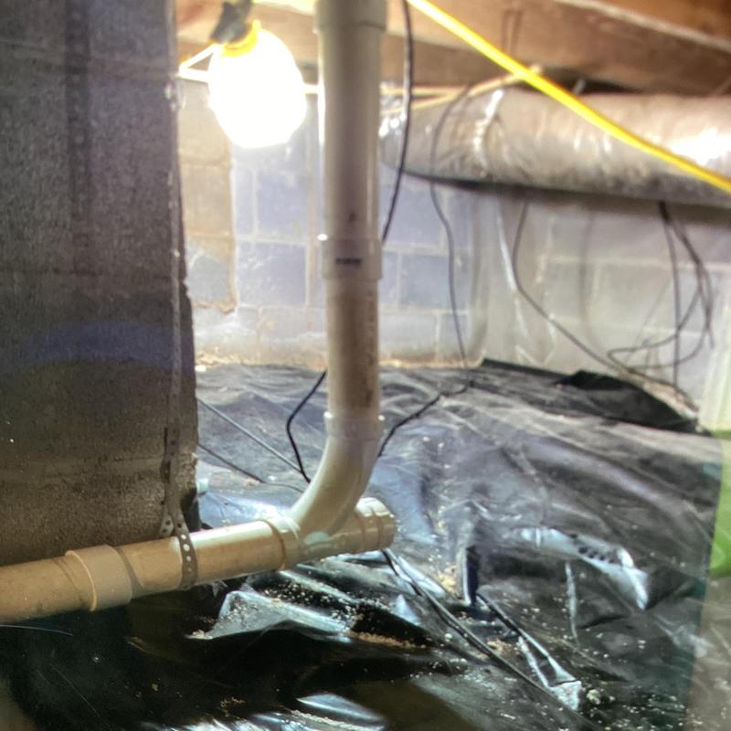 PVC pipe crossover tee in crawl space installation