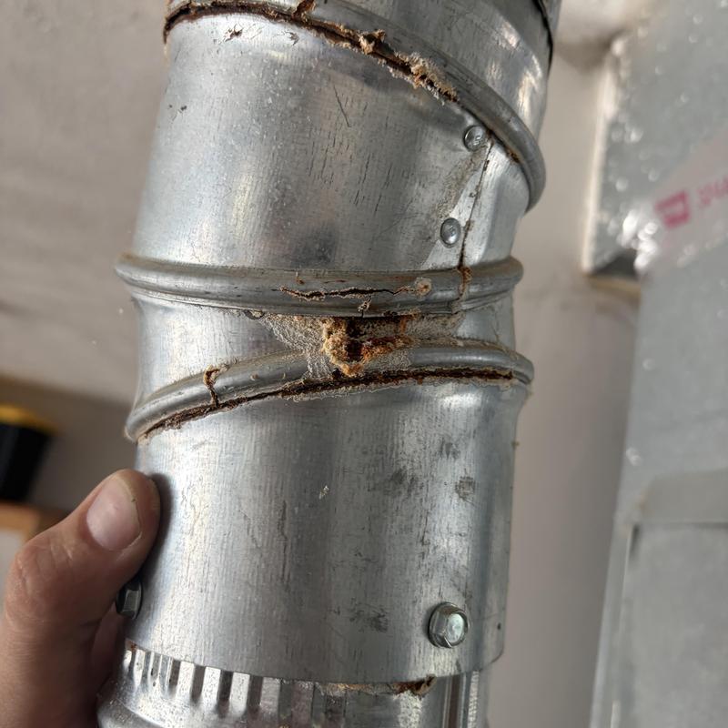 Rust damaged metal flue pipe section requiring replacement