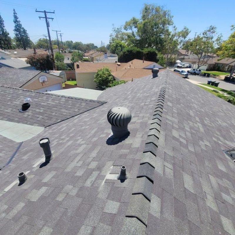 Shingle roof with ventilation turrets in residential area Shingle roof with ventilation turrets in residential area