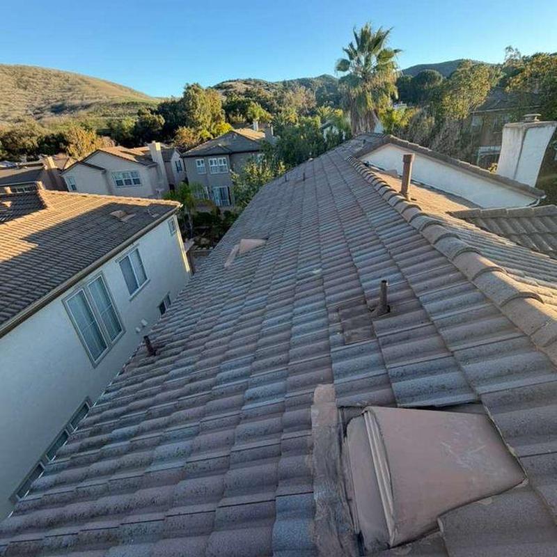 Tile roof with vent pipes and chimney in residential area Tile roof with vent pipes and chimney in residential area