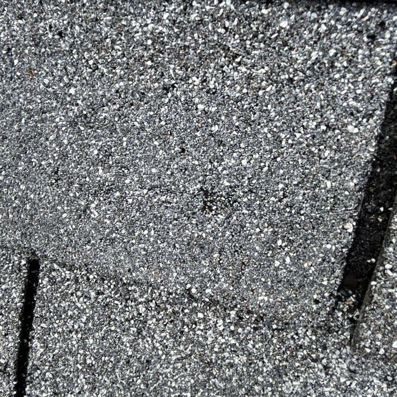 Asphalt roofing shingles with hail damage close-up