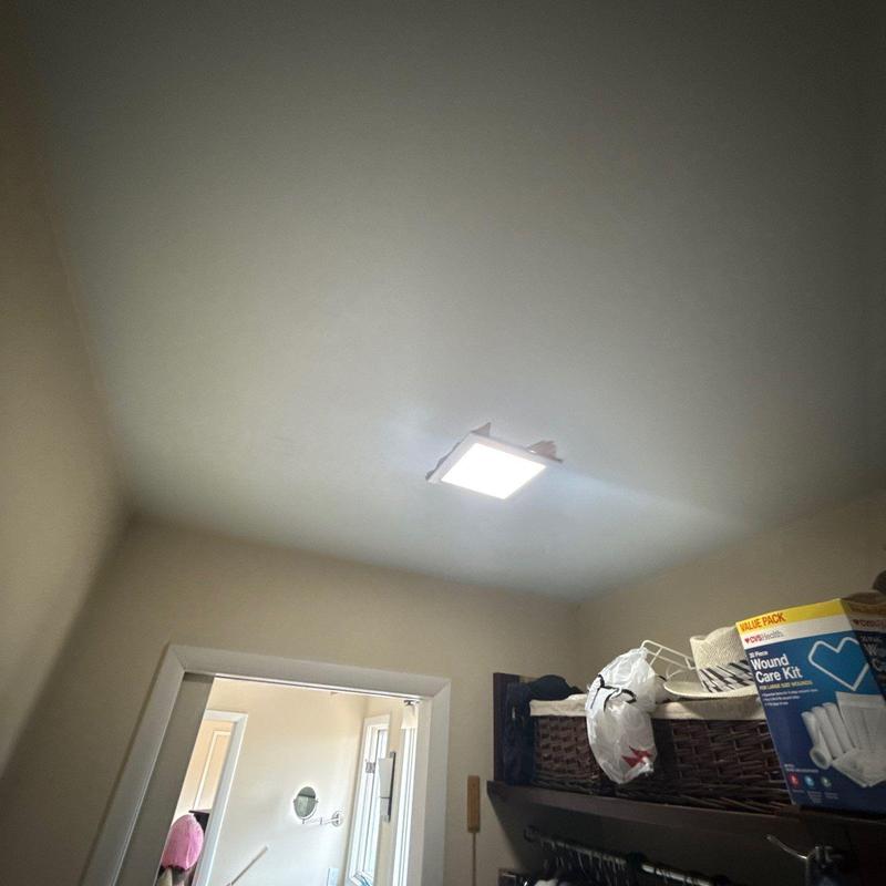 Ceiling LED light fixture with damaged drywall surrounding