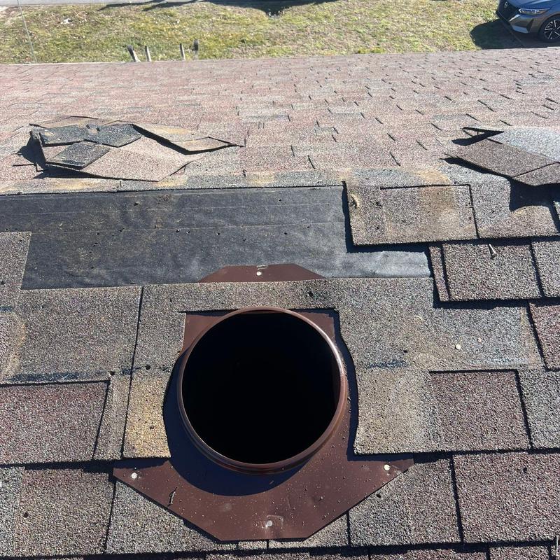 Roof vent with missing shingles and exposed underlayment