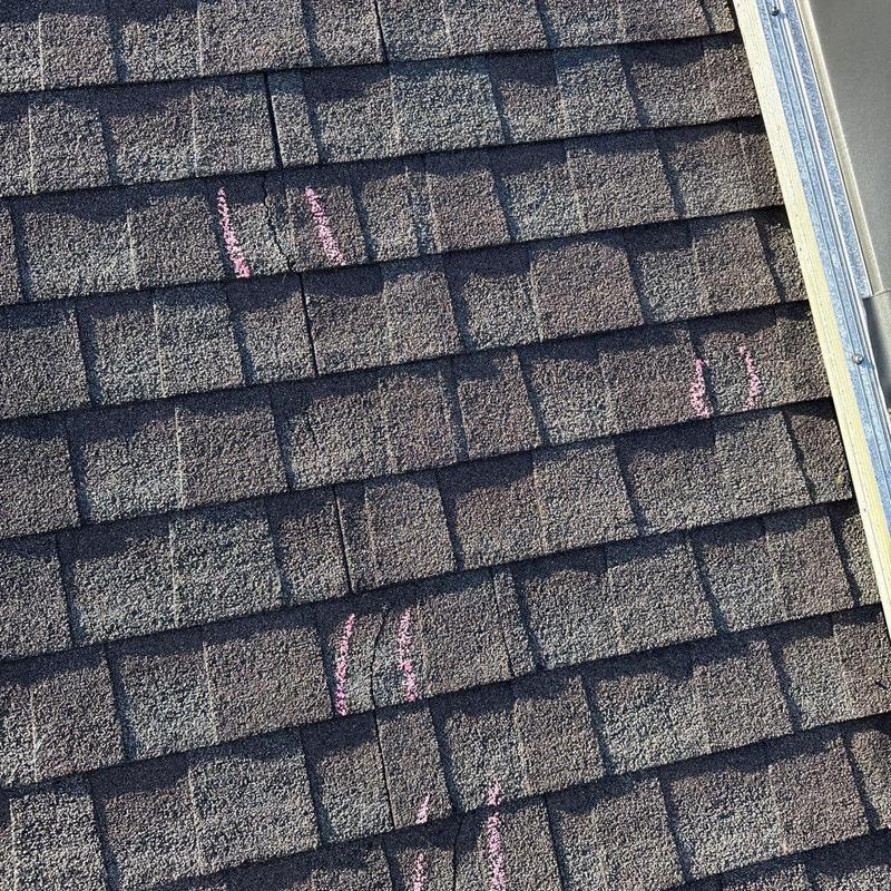 Asphalt shingles with hail damage marked for repair