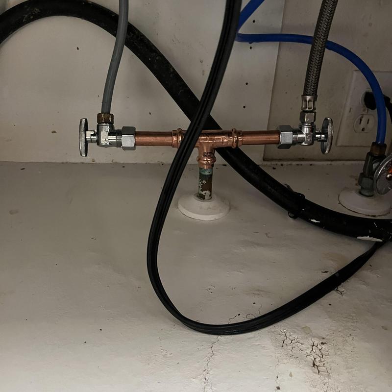 Copper dual stop valve under kitchen sink with pipes Copper dual stop valve under kitchen sink with pipes