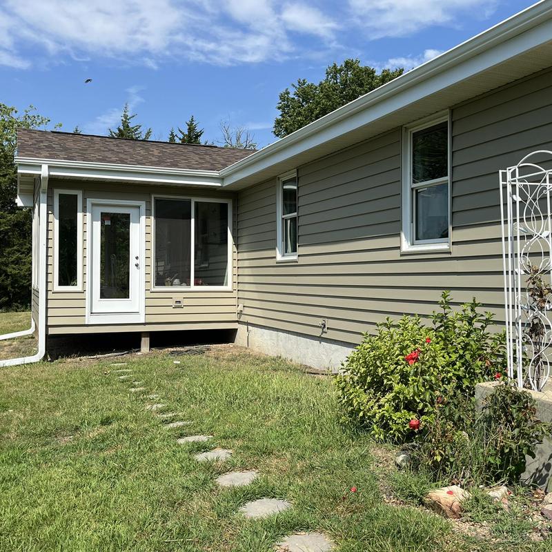 Aluminum gutters with downspouts on beige house exterior Aluminum gutters with downspouts on beige house exterior