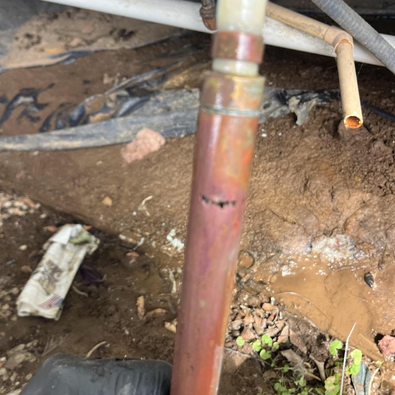 Copper water pipe with visible corrosion and hole