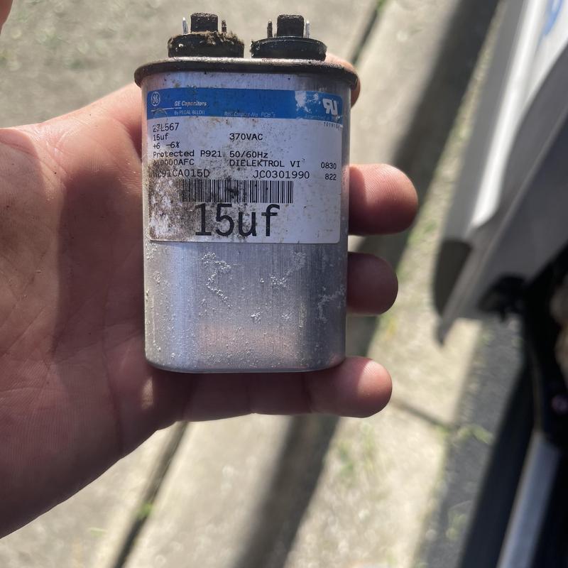 AC blower motor start assist capacitor held in hand