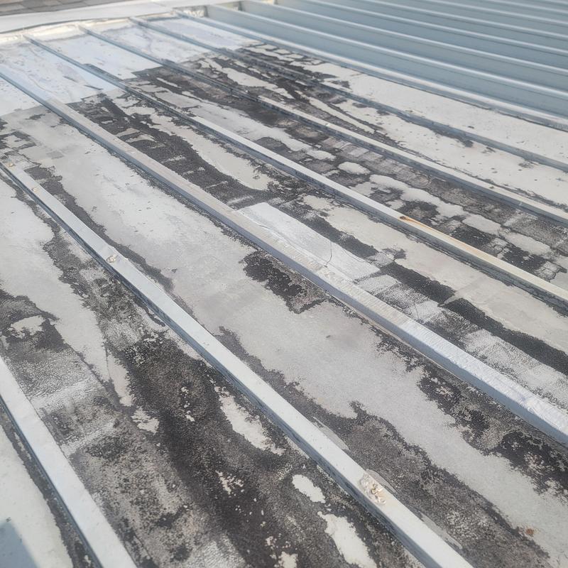Flat metal roof panels with deteriorated sealant Flat metal roof panels with deteriorated sealant