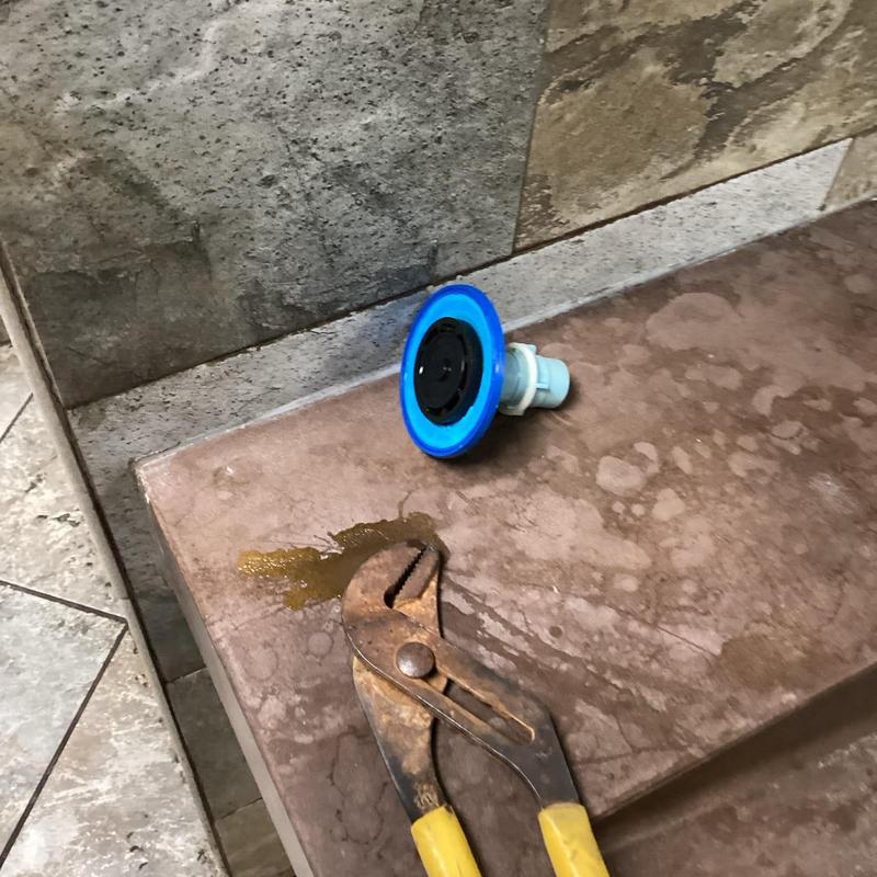 Zurn urinal flush valve and pliers on tiled surface