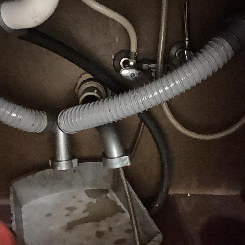 Kitchen sink drain line with flexible hoses under cabinet
